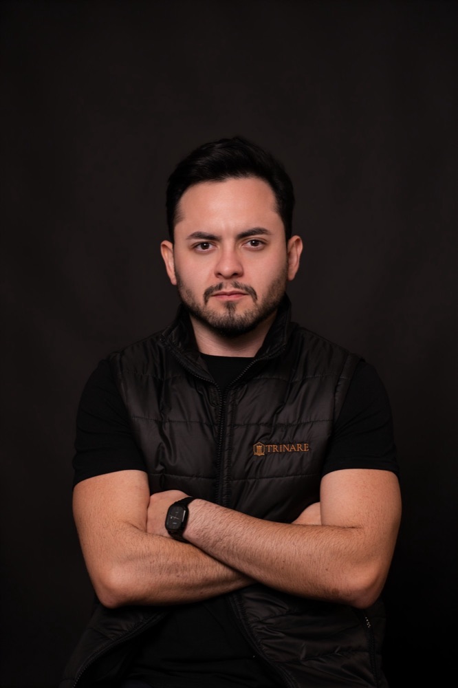 Daniel Bianchi, de braços cruzados, usando colete preto da Trinare